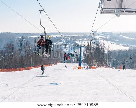 Skiers And Snouborders On A Ski Lift Pov In Winter Time. The Cable Car Lifts The Peoples Up To The S