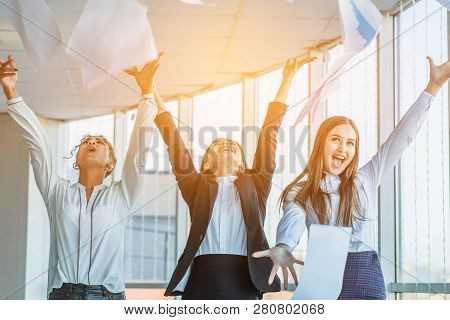Three Young Beautiful Brunette Business Ladies In The Office. All Happy Dancing Dancing Up The Docum
