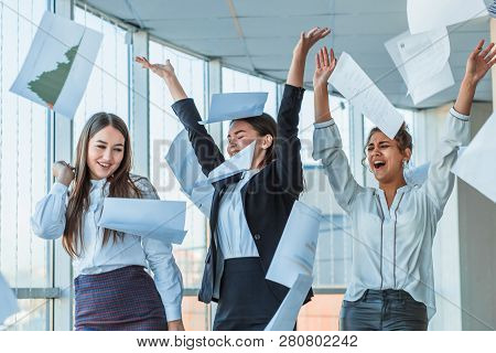 Three Young Beautiful Brunette Business Ladies In The Office. All Happy Dancing Dancing Up The Docum