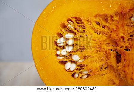 Tasty And Healthy And Fleshy Vegetable - Juicy, Bright Orange Pumpkin In A Cut With Seeds Close Up. 