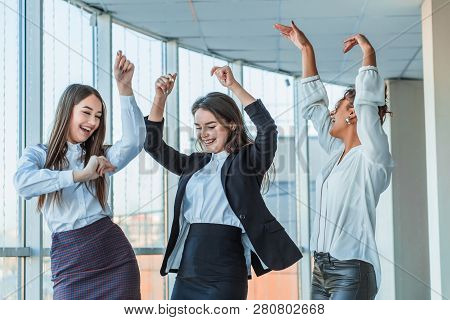 Three Young Beautiful Brunette Business Ladies In The Office. All Happy Dancing Dancing Up With Copy