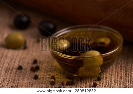 Fresh Bread Baguette With Olive Oil, Olives. Cheese And Rosemary On Wooden Background. Teasty Breakf