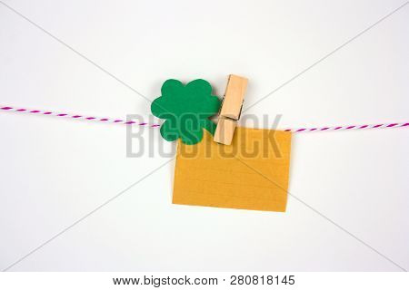 Old Vintage Paper Mock Up And Shamrock Paper Cut Leaves On Clothespin On White Bakground