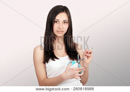 Stop Smoking. Quit Smoking Womens Hands Holding A Bunch Of Cigarettes And Cut Them In Half Scissors.