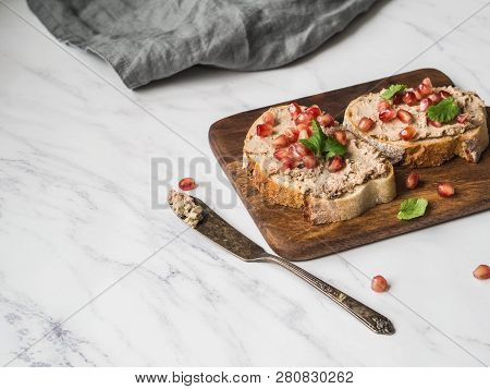 Two Toasts Duck With Prunes Rillettes Pate On White Bread With Pomegranate Seeds On A Wood Board On 