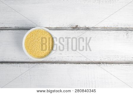 Dry Couscous In White Ceramic Bowl Isolated On Grey. Spilled Couscous.