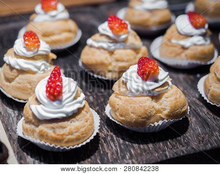 Fresh Cream Puffs Filled With Whipped Cream And Strawberry On Top