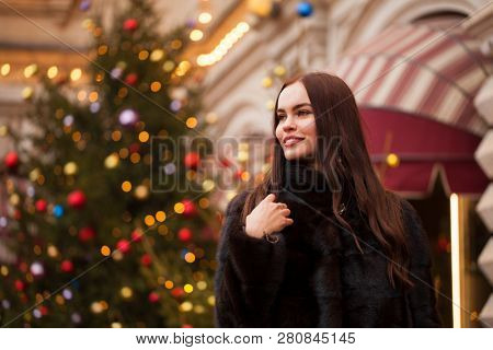 Portrait of a Young beautiful brunette woman in mink fur coat, posing in winter Red Square in central Moscow