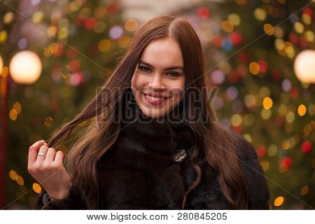 Portrait of a Young beautiful brunette woman in mink fur coat, posing in winter Red Square in central Moscow