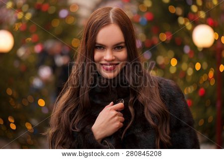 Portrait of a Young beautiful brunette woman in mink fur coat, posing in winter Red Square in central Moscow