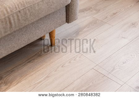 Grey Sofa With Wooden Legs On Lamonate Floor