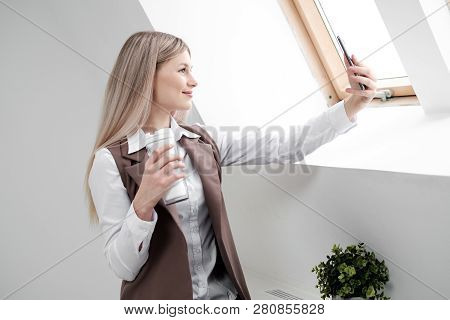 Blonde Girl In A Business Suit Works On A Computer In A White Bright Office.