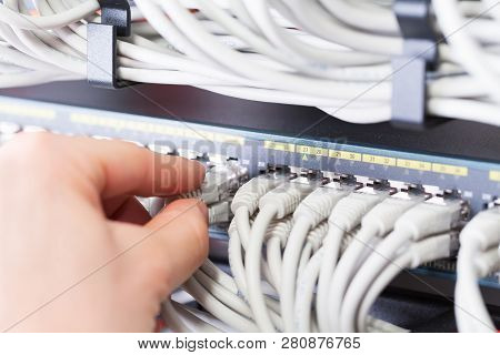 It Consultant Connects A Network Cable Into Switch In Datacenter
