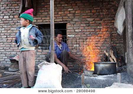 KATHMANDU, Nepál - 7. ledna: Pracovník Štěpán Kumar a jeho syn Pavel (vlevo) brusný nástroj chudý