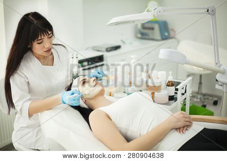 Girl At Spa Salon. Beautician Applying White Cosmetic Powder