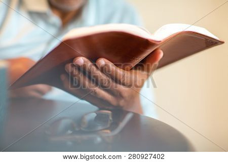 African American Man Praying And Reading The Bible.