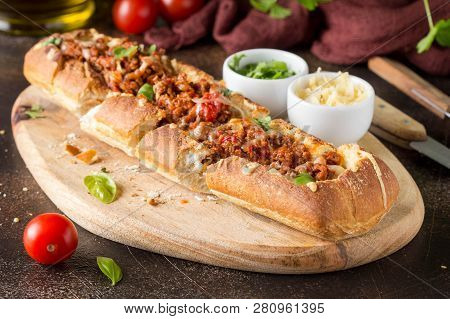 Baguette Stuffed With Bolognese Ragout Of Minced Beef, Tomatoes And Cheese. A Delicious Italian Lunc