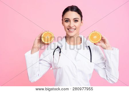 Portrait Of Smiling Female Doctor In White Gown With Stethoscope Holding Oranges Isolated.