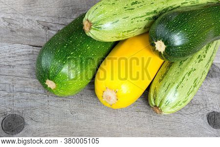 Zucchini On Wooden Background. Yellow And Green Zucchini. Vegetable Marrow Courgette Or Zucchini. Ha