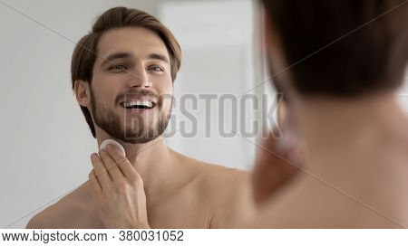 Close Up Mirror Reflection Overjoyed Young Man Applying Aftershave Lotion