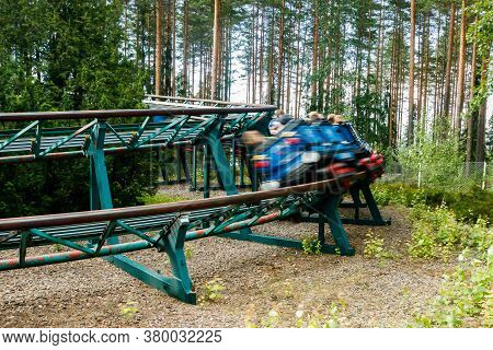 Ride Roller Coaster In Motion In Amusement Park At Summer Day