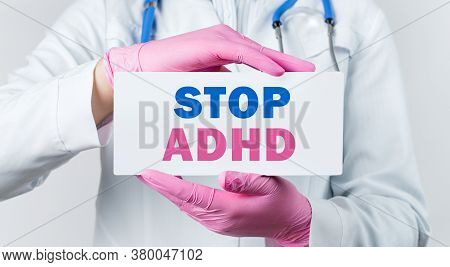 Cropped View Of Young Female Doctor In A White Coat And Pink Sterile Gloves Holding A Card With Text
