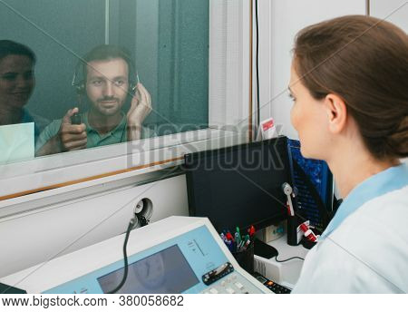 Mixed Race Man Getting A Hearing Test At A Doctors Office, Audiometer Hearing Test In A Special Audi
