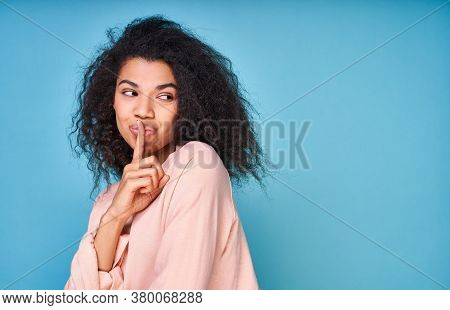 Dont Slip A Word. Attractive Playful Black Woman Holding Her Finger On Her Lips Asking To Be Kept Se