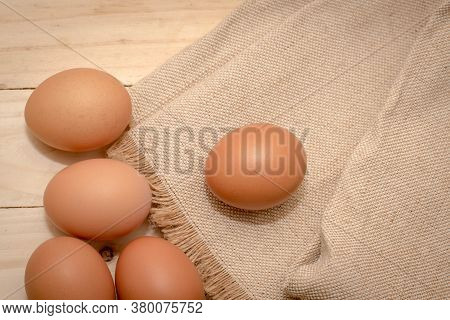 Brown And White Organic Chicken Eggs In A Brown Paper Box Placed On A White Wooden Table. Eggs Provi