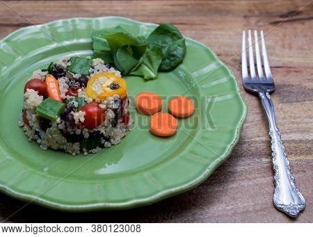 Green Plate With Quinoa Salad Shaped As Small Cake On Wooden Table, - Quinoa Is A Pseudo-grain That 