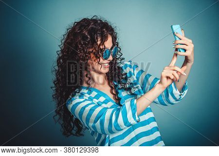 Selfie Timel. Smiling Woman Making Selfie With Smartphone Isloated On Blue Background Wall. Happy Wo