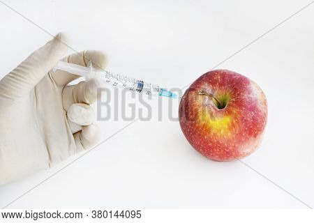 Injection Into Red Apple - Genetically Modified Fruit And Syringe With Red Chemical. Gmo Food. Labor