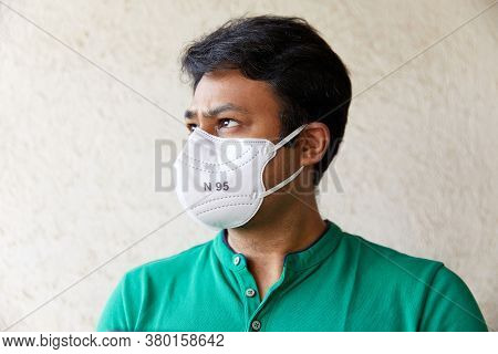 Adult Indian Man Wearing White N95 Mask In Green Polo T-shirt Looking Into The Camera With Head Face