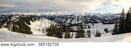 Snow Covered Mountains And Trees. Amazing Panoramic Snowy Winter Landscape In Alps At Sunrise Mornin