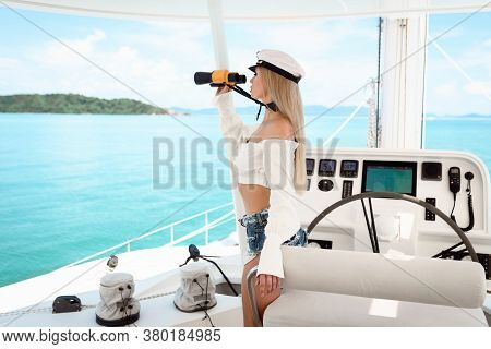 Attractive Blonde At The Wheel Of A Yacht