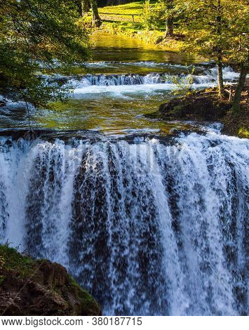 Magnificent cascade of waterfalls on the Korana River. The forest surround the river. The small Croatian town of Slunj. The concept of ecological, active and photo tourism