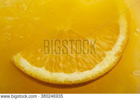 Top View Macro Detail Of Slice Of Orange Floating In Crushed Ice Of Orange Margarita Cocktail With T