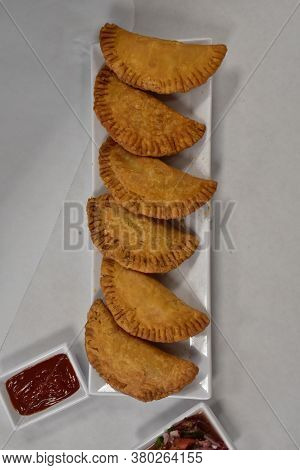 Crispy Empenadas On A Long White Plate