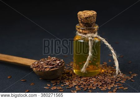 Linseed Oil Bottle And Flax Seeds On A Dark Background.
