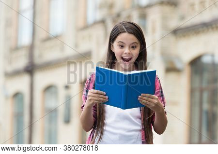 Discover Something New. Happy Child Read Book Outdoors. Excited Bookworm With Open Mouth. School Lib
