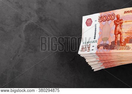 Russian Cash Banknotes Of Five Thousand Rubles, The Bundle Hangs On A Gray Background.