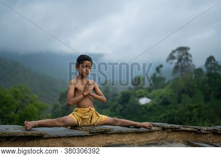 A Young Indian Cute Kid Doing Yoga In The Mountains,wearing A Dhoti