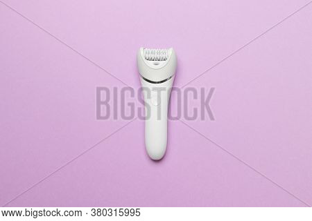 Women Epilator On Purple Colored Paper Background, Top View.