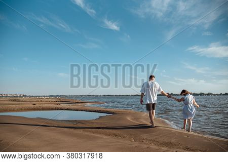 Couple In Love On The Beach.young Man And Woman Walking On Seashore And Laughing.