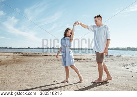 Couple In Love On The Beach.young Man And Woman Walking On Seashore And Laughing.