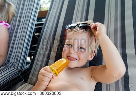 Two Cute Adorable Caucasian Blond Little Siblings Enjoy Having Fun Relaxing And Eat Fruit Popsicle I