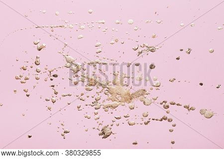 Gold Potal Drops And Splashes On Pale Pink Paper. Creative Background