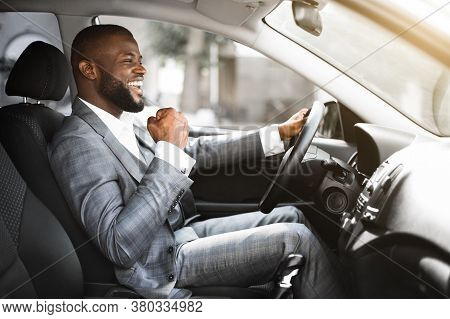 Young Emotional Black Businessman In Suit Driving After Successful Business Meeting, Celebrating Suc