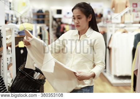 Women Looking Clothes In Shopping Mall. Asian Women Smileing Happy To Choice And Tried Clothes In Sh