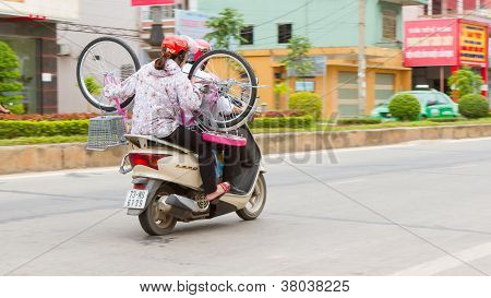 Dong Hoi, Vietnam, 7 August 2012 - Vietnamese Family With A Bicycle On A Scooter. With An Estimated